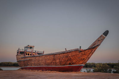 Boat on beach against clear sky