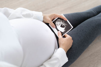 Midsection of woman holding camera