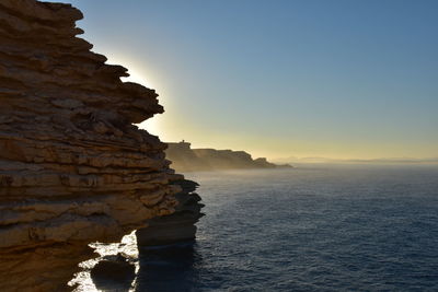 Scenic view of rock formation in sea against sky