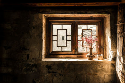 Flower vase on window sill in old house