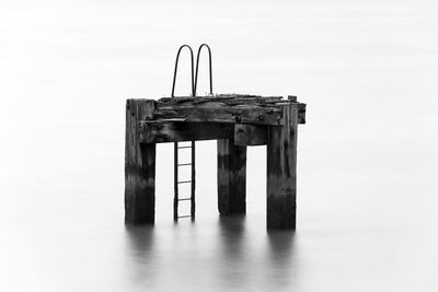 Old pier over sea against sky