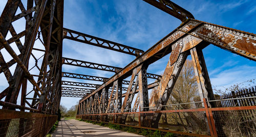 Shot of old rusty bridge set against a countryside and blue sky background