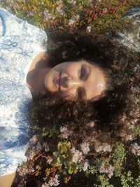 Portrait of smiling young woman against plants