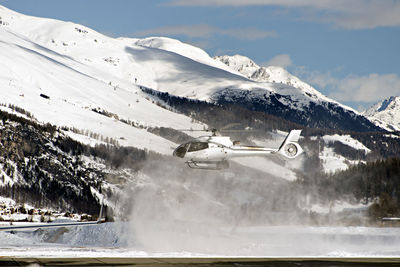 Helicopter landing at engadine st moritz airport in winter