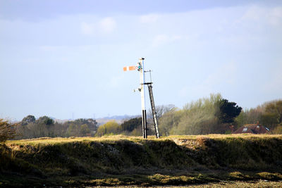 Windmill on field against sky