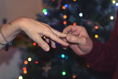 Midsection of man and woman holding illuminated lights