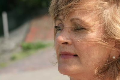 Close-up of woman with blond hair looking away outdoors