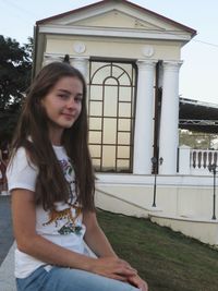 Portrait of young woman sitting outdoors