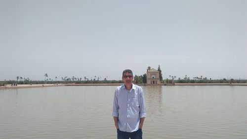 Portrait of man standing against lake