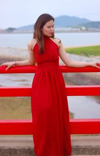 Young woman standing against red water