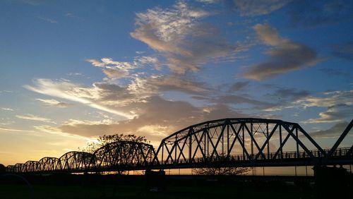 Silhouette bridge against sky during sunset