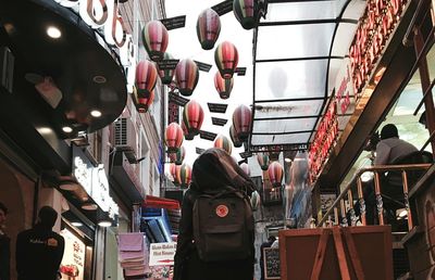 Rear view of woman hanging in market