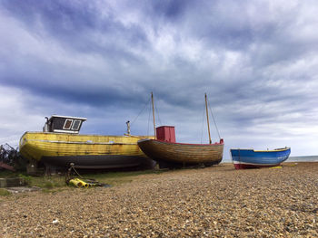 Boats moored on beach against sky