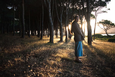 Woman standing by trees at beach