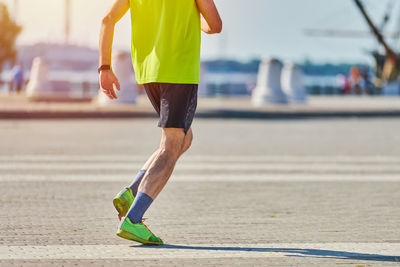 Running man. athletic man jogging in sportswear on city road. healthy lifestyle, fitness sport hobby