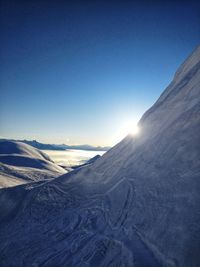 Scenic view of snow mountains against clear blue sky