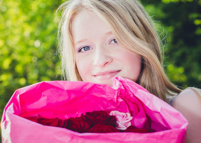 Portrait of smiling young women with bunch of roses