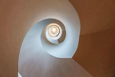 Directly below shot of illuminated light fixture on ceiling of building