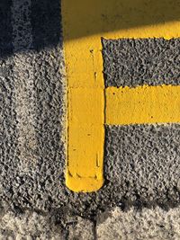 High angle view of yellow road markings on tarmac.