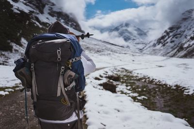 Rear view of male hiker hiking on snowcapped mountain