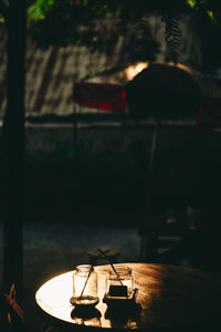 Close-up of illuminated lamp on table in city at night