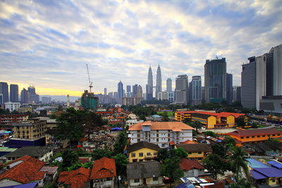 View of cityscape against cloudy sky