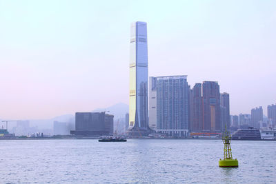 Scenic view of river by buildings against clear sky