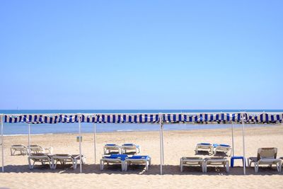 Lounge chairs at beach during sunny day