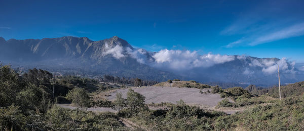 Scenic view of mountains against blue sky
