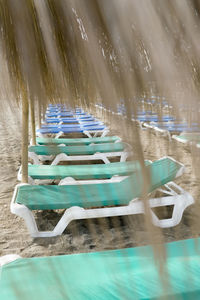 Empty chairs by swimming pool