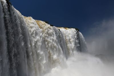 Scenic view of waterfall against sky