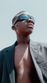 Low angle view of young man against clear sky