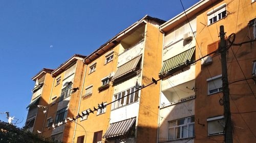 Low angle view of buildings against clear blue sky