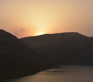 Scenic view of silhouette mountains against sky during sunset