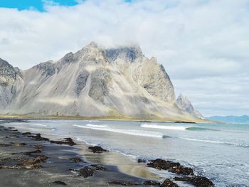 Scenic view of sea and mountains against sky