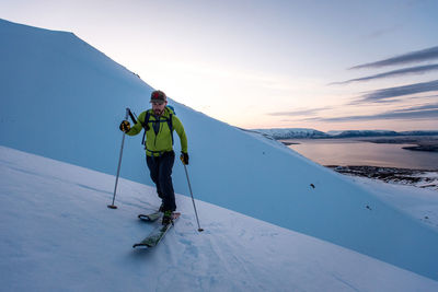 Man backcountry skiing in iceland at sunrise