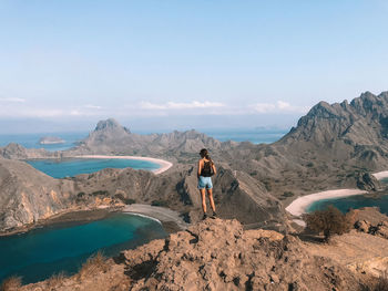 Rear view of man on mountain against sky