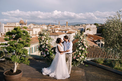 Couple holding umbrella against built structure