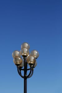 Low angle view of lamp post against clear blue sky