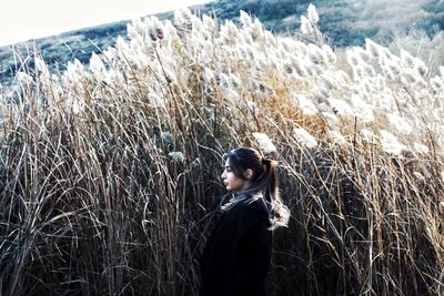 Side view of woman standing in field