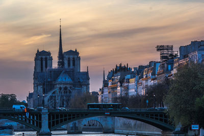 View of bridge and buildings against sky during sunset