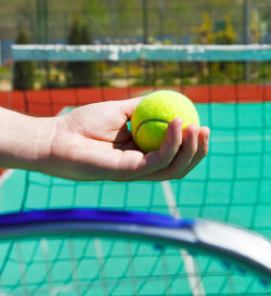 Cropped hand of person holding tennis ball