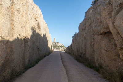 Road amidst rocks against clear sky