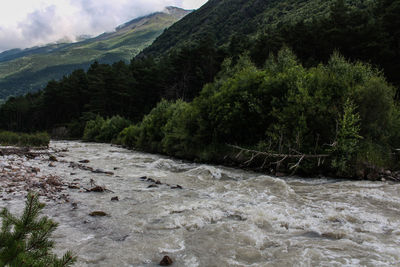 Scenic view of river and mountains against sky