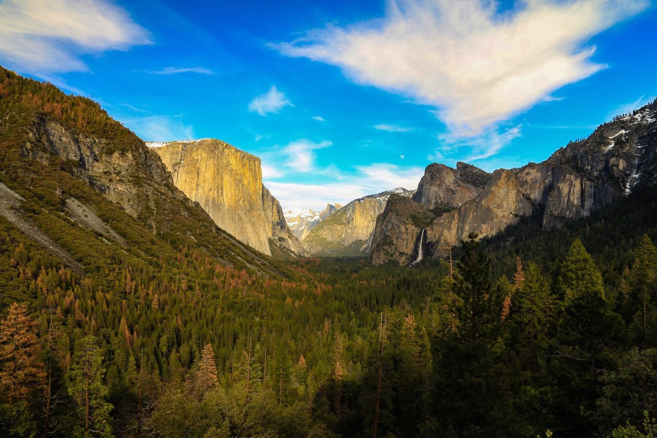 mountain, sky, tranquility, tranquil scene, scenics, mountain range, beauty in nature, blue, landscape, nature, rock formation, cloud, non-urban scene, cloud - sky, rocky mountains, geology, idyllic, tree, physical geography, day