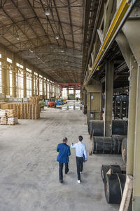 Two men walking through factory hall