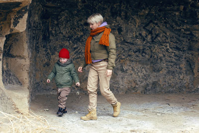 Mom walks with her child in the fall in the rock