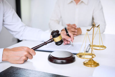 Male lawyer sitting with customer at desk in office