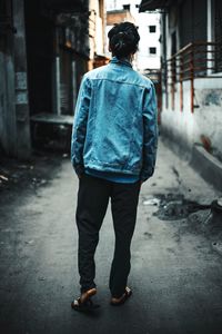 Rear view of man walking on street in city