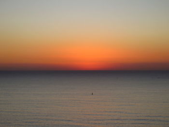 Scenic view of sea against orange sky